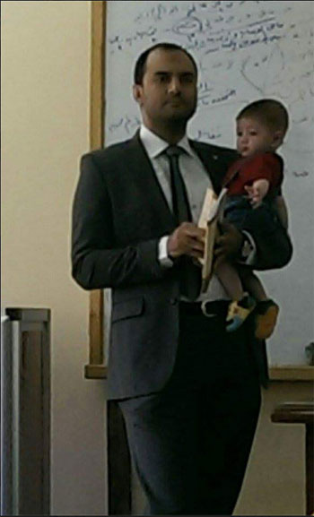 أستاذ جامعى يحمل طفل إحدى طالباته أثناء المحاضرة (1)