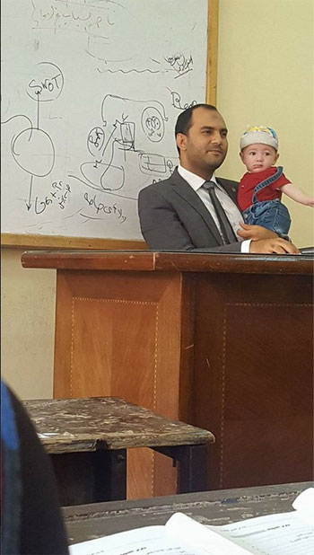 أستاذ جامعى يحمل طفل إحدى طالباته أثناء المحاضرة (2)