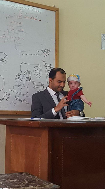 أستاذ جامعى يحمل طفل إحدى طالباته أثناء المحاضرة (3)