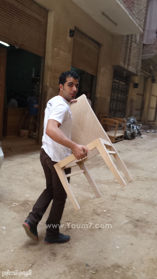 شاب يرتدى تشرت المبادرة وينقل خشب من ورشة لورشة -اليوم السابع -6 -2015