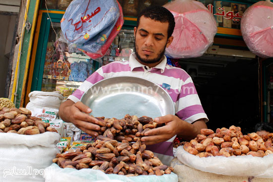 تاجر يجهز عرض التمور بشارع تجارى  -اليوم السابع -6 -2015