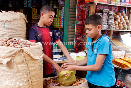 طفلان يتعاونان على ضبط البلح أمام الزبائن  -اليوم السابع -6 -2015
