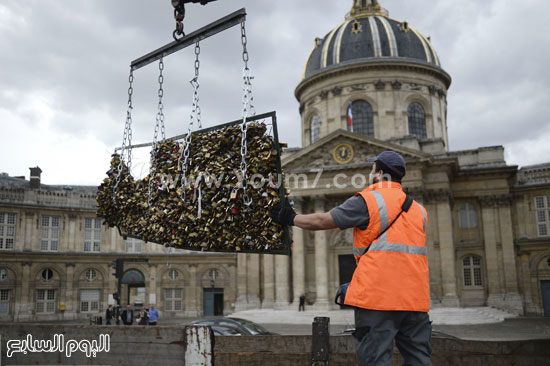 أحد العمال من بلدية باريس يقوم برفع كمية كبيرة من الأقفال -اليوم السابع -6 -2015