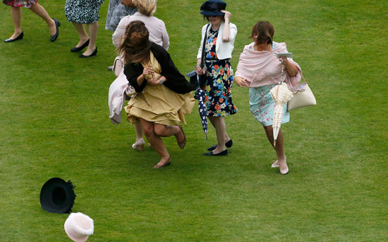 السيدات تلاحق قبعاتهن التى قذفتها الرياح القوية خلال حفل بقصر باكنجهام. -اليوم السابع -6 -2015