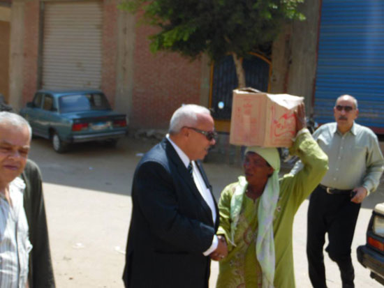 رئيس مدينة قطور خلال توزيع كراتين السلع الغذائية للمستحقين -اليوم السابع -7 -2015