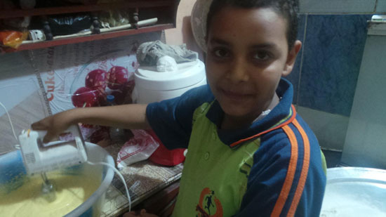 طفل يمسك بماكينة ضرب مكونات الكحك -اليوم السابع -7 -2015
