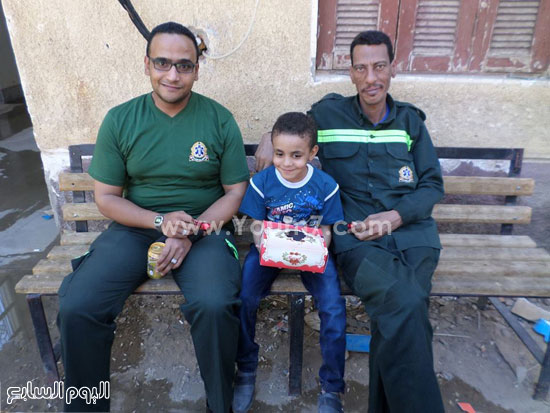 طفل يقوم بتوزيع الحلوى على أفراد الشرطة بالخارجة -اليوم السابع -7 -2015