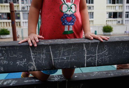 فتاه صغيرة تسند يدها على سور يظهر عليه لعبة المنحنيات الشهيرة حول العالم -اليوم السابع -7 -2015