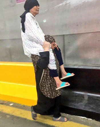 سيدة مصرية تحمل والدتها العجوز على كتفها  (1)