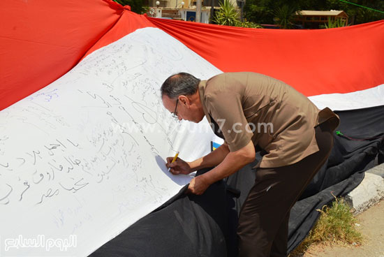 	احد الموطنين يوقع على علم مصر بسوهاج  -اليوم السابع -8 -2015