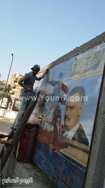 	احد العمال يعلق جدارية للرؤساء بالقليوبية -اليوم السابع -8 -2015