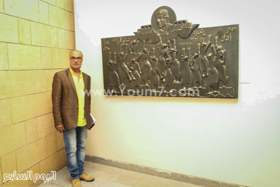 	الفنان إيهاب الأسيوطى بجانب جدارية 