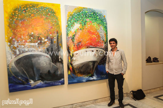 	الفنان محمود المنيسى بجانب لوحتيه عن القوافل العابرة بقناة السويس -اليوم السابع -8 -2015