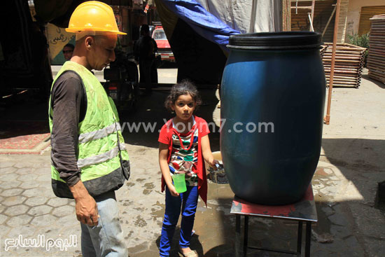 طفلة تملأ المياه من الشارع لعدم وجود ملجأ فى بيتها لشرب الماء -اليوم السابع -8 -2015