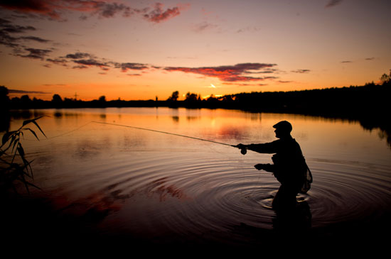 أحد الأشخاص يقوم بالصيد وقت الغروب فى إحدى البحيرات بمدينة ليرته الألمانية  -اليوم السابع -9 -2015