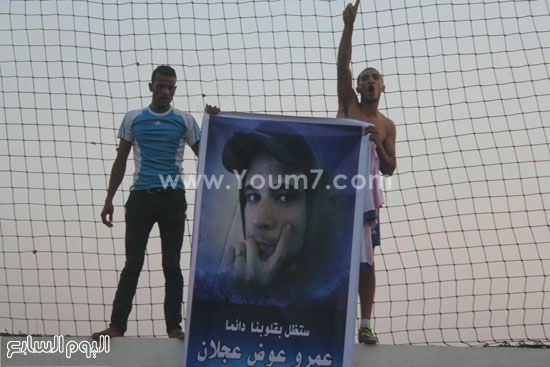 	أسرة شهيد يرفعون لافتة تحمل صورته -اليوم السابع -9 -2015