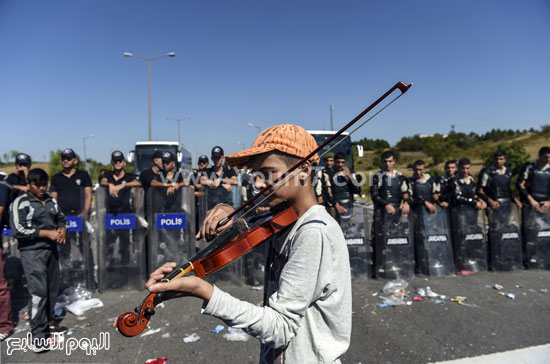  أحد الأشخاص يقوم بعزف الكمان أمام قوات الشرطة -اليوم السابع -9 -2015