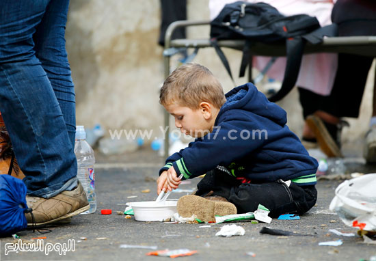 أحد الأطفال يتناول طعامه فى نقطة حدودية نمساوية وسط تفاقم أزمة اللاجئين الهاربين من ويلات الحروب فى سوريا -اليوم السابع -9 -2015