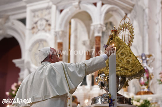 البابا يضئ الشموع أمام تمثال 