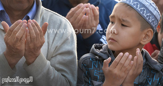 طفل من قيرغيزستان يرفع يده بالدعاء خلال صلاة عيد الأضحى. -اليوم السابع -9 -2015