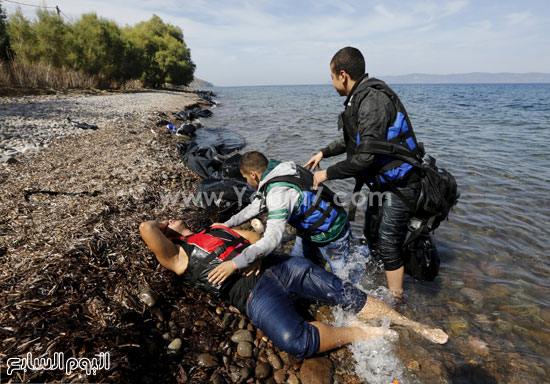 	بعض من المهاجرين معه يحاولون إنقاذه. -اليوم السابع -9 -2015