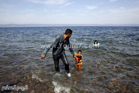 	أب يسحب طفله من الماء بعد اقترابهم من الشاطئ. -اليوم السابع -9 -2015