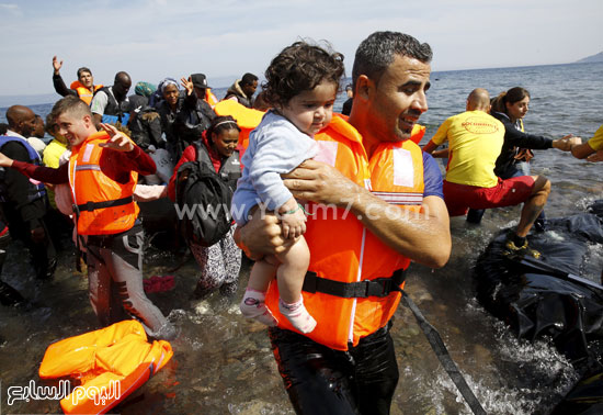 	أحد قوات الأنقاذ يحمل طفلا صغيرا. -اليوم السابع -9 -2015