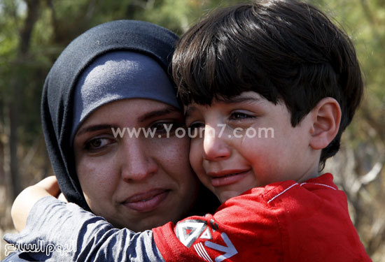 	أم تحمل طفلها الذى يبكى من الخوف. -اليوم السابع -9 -2015