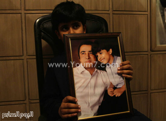  على مرتضى جيلانى يحمل صورة ابيه الذى توفى فى الحادث مولتان – باكستان -اليوم السابع -9 -2015