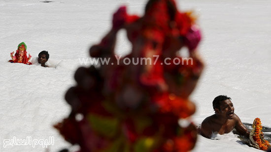 المحتفلون يحملون تماثيل الإله جانيش ويغمروها فى مياه النهر  -اليوم السابع -9 -2015