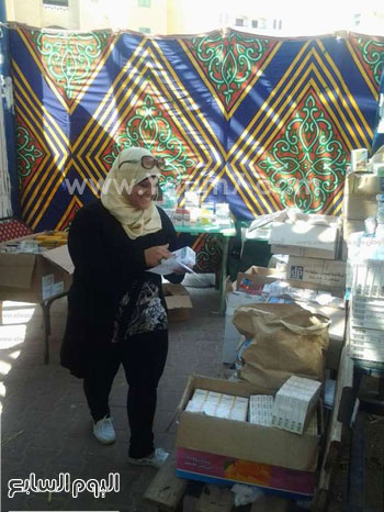   رانيا رئيس فريق المتطوعين بنهر الحياة خلال صرفها بعض الأدوية -اليوم السابع -9 -2015