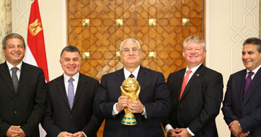 بالصور..الرئيس منصور يحمل كأس العالم خلال لقائه وفد "فيفا"
