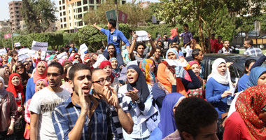 طلاب الإخوان بجامعة القاهرة يعلقون إشارة رابعة على باب كلية التجارة