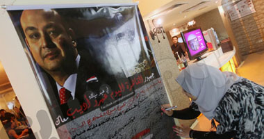 إحدى الفتيات تكتب رسالة تهنئة لأديب.