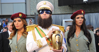 الممثل ساشا بارون كوهين بزى الديكاتور وخلفه المرافقات