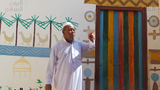عم محمد يشير إلى الرسومات على الجدران