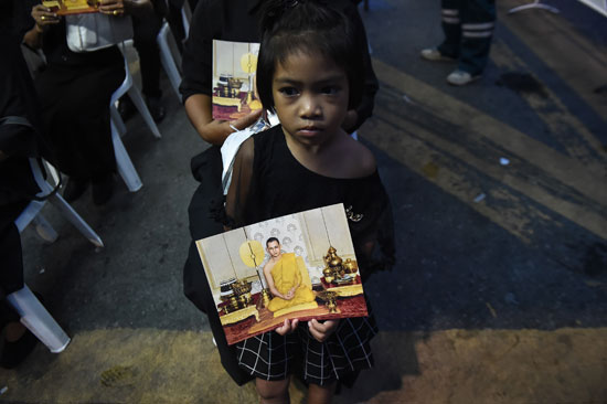 طفلة تحمل صورة لملك تايلاند الراحل