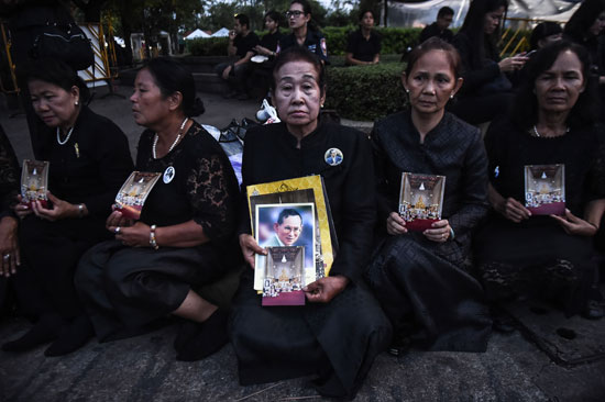 سيدات تحملن صورة لملك تايلاند الراحل