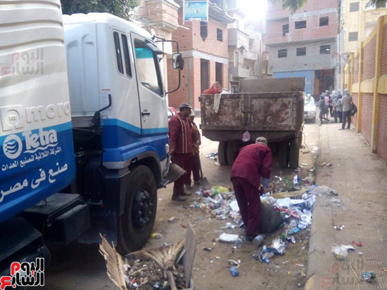 العمال في شارع دسق لرفع القمامة