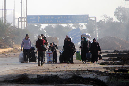 سوريون يحملون أمتعتهم وهم يغادرون الخطوط الأمامية فى معارك حلب