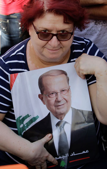 سيدة لبنانية تمسك بصورة الرئيس عون