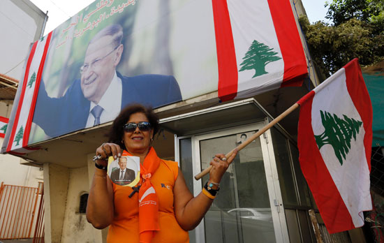 لبنانية تمسك بعلمها وفى اليد الأخرى صورة ميشيل عون