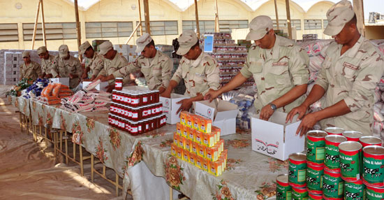 جنود القوات المسلحة يجهزون عبوات السلع المخفضة تمهيدًا لتوزيعها على المواطنين
