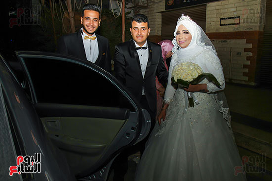العروسين يستقلون سيارة الزفاف
