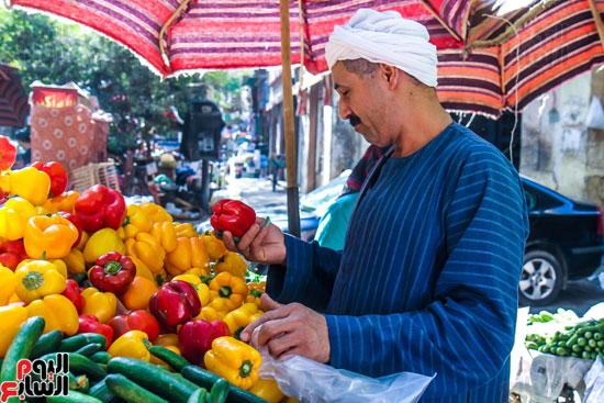 البائع يتفحص السلعة فى انتظار الزبائن