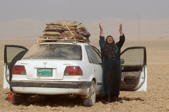 امرأة عراقية تتضرع إلي الله بعد هروبها من جحيم حرب الموصل