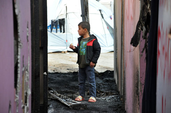 طفل سورى يشاهد آثار الحريق