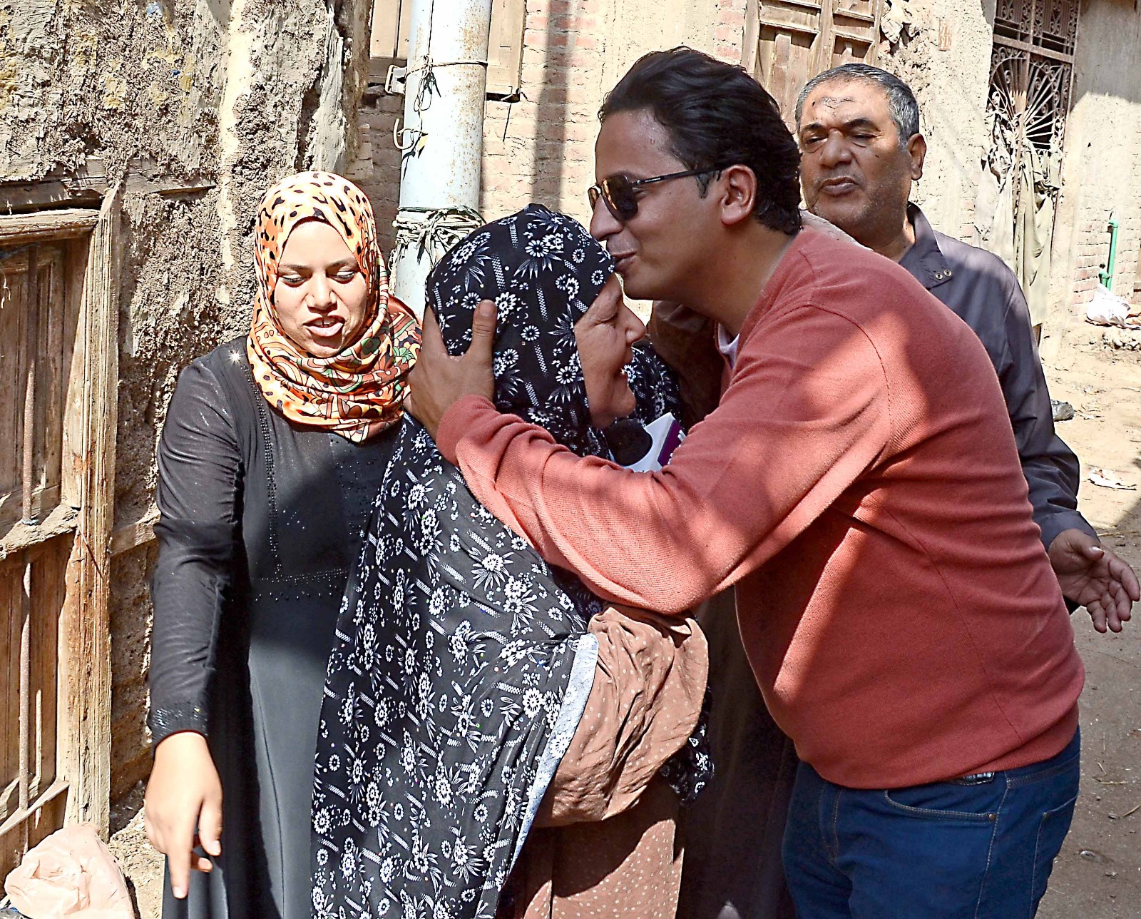 أحمد رجب يقبل رأس سيدة من قرية أحمد عرابى