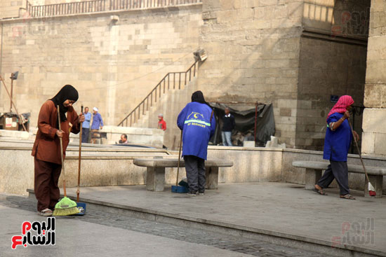 عمال النظافة يزينون شارع المعز