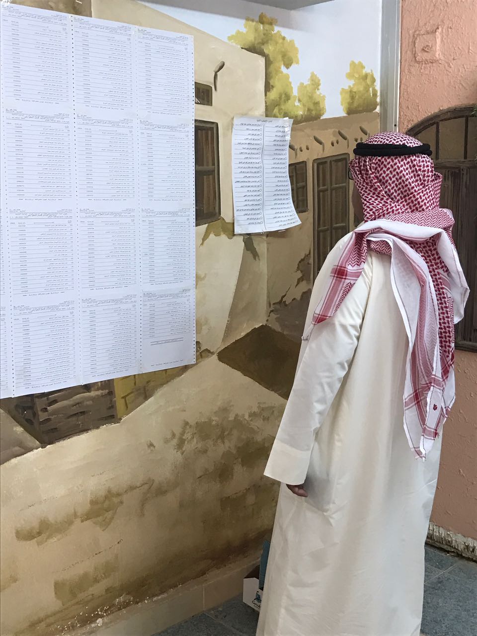 مواطن كويتى يبحث عن اسمه فى كشوف الناخبين